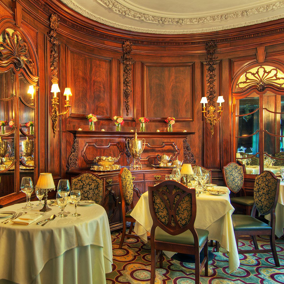 An elegant dining room with fully set tables and opulent furnishings